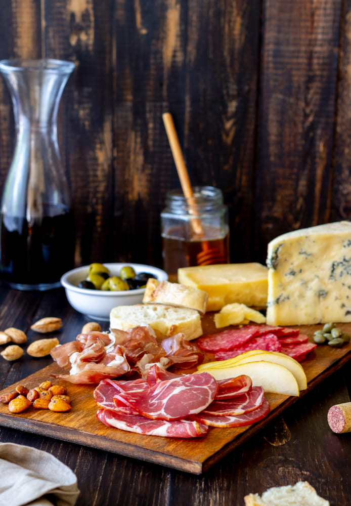 Tabla con jamones y queso Colombo Alemana, quesos variados, frutas y pan artesanal