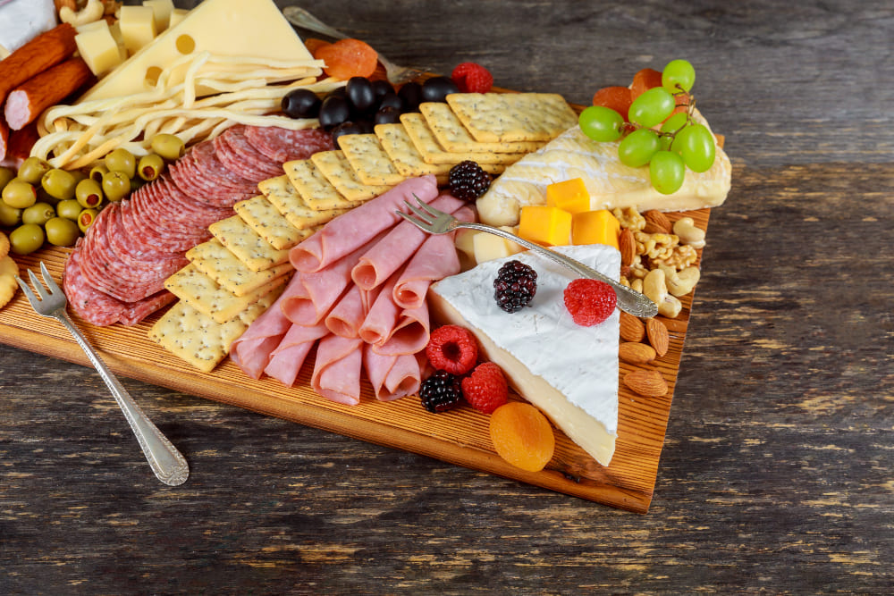 Tabla con jamones y queso Colombo Alemana, quesos variados, frutas y pan artesanal