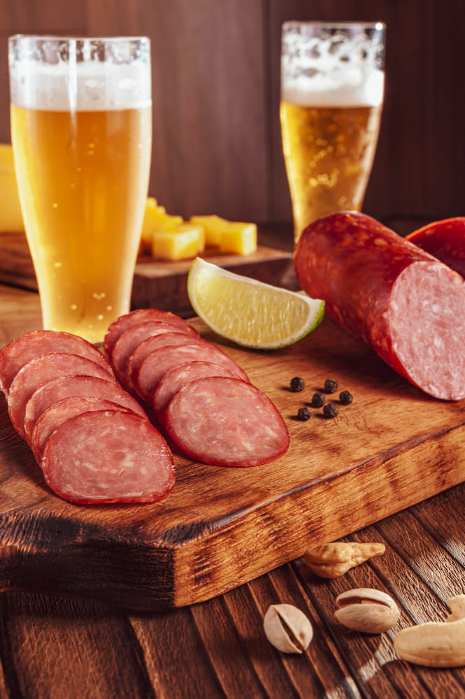 Tabla de embutidos Colombo Alemana con copas de vino y cerveza para maridaje