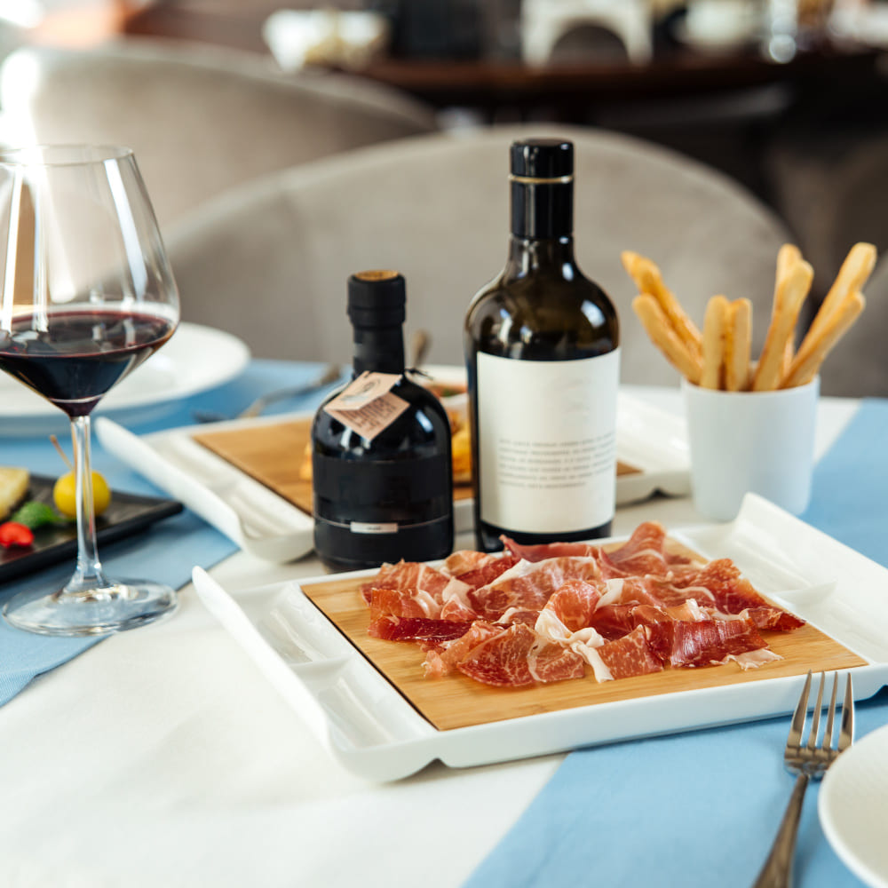 Tabla de embutidos Colombo Alemana con copas de vino y cerveza para maridaje