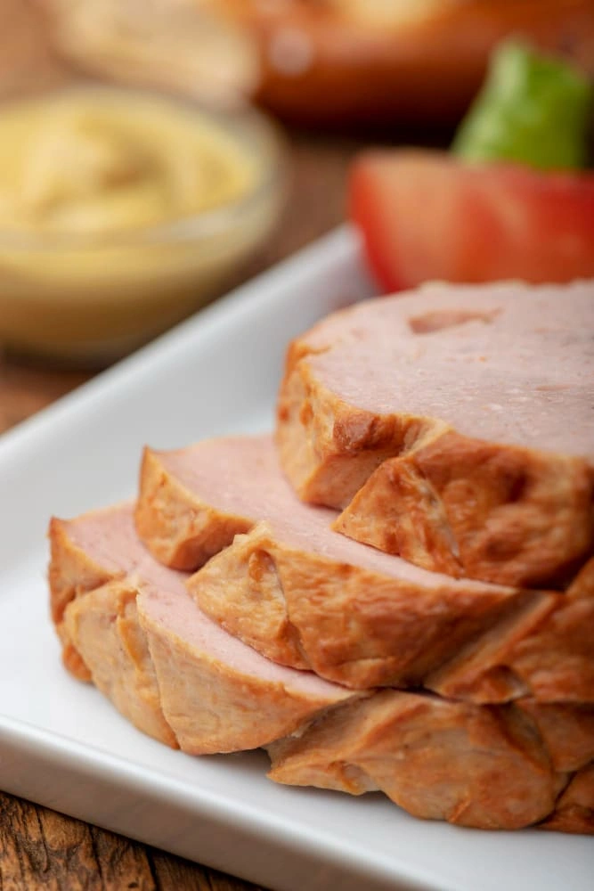 Lomo Ahumado de Cerdo Colombo Alemana en una tabla gourmet con vegetales asados